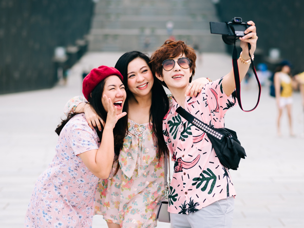 photo of three south east asian people taking a selfie 